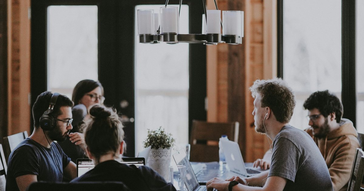 Freelancers working on laptops around a shared table